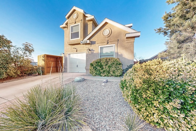 view of front of property featuring a garage, driveway, and stucco siding