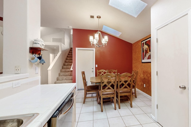 dining room featuring a notable chandelier, light tile patterned floors, visible vents, vaulted ceiling with skylight, and stairs