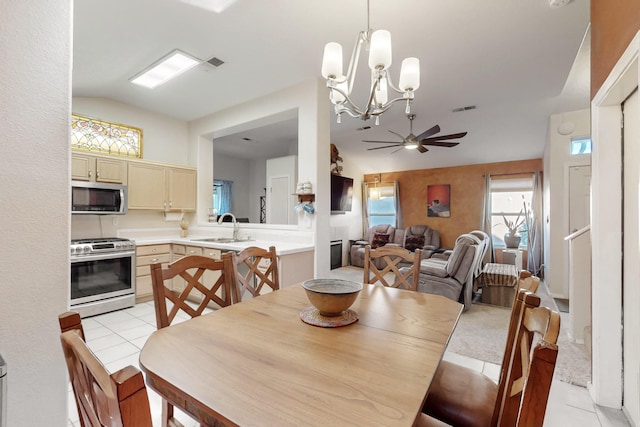 dining room featuring ceiling fan, vaulted ceiling, light tile patterned flooring, and visible vents