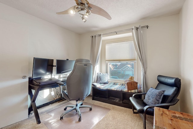 carpeted office featuring a ceiling fan and a textured ceiling