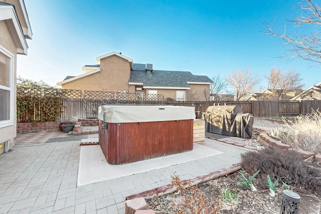 view of patio with a fenced backyard and a hot tub