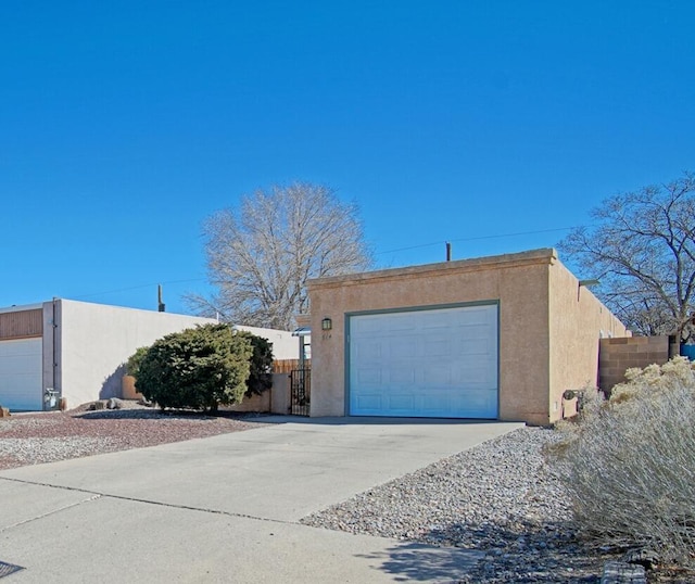 view of side of property with a garage, driveway, an outbuilding, and stucco siding