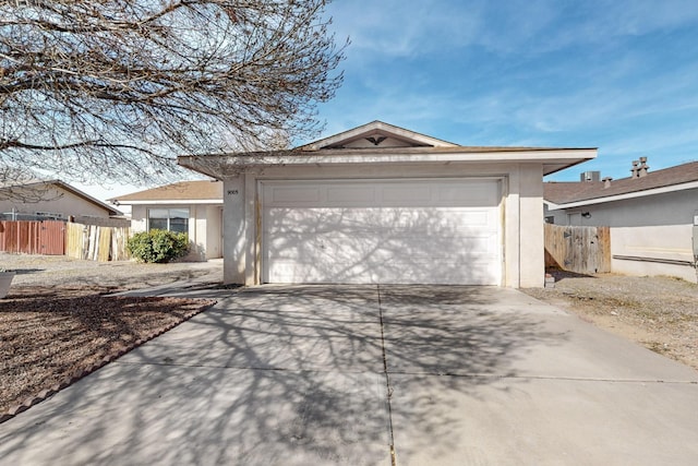 single story home featuring a garage, concrete driveway, fence, and stucco siding