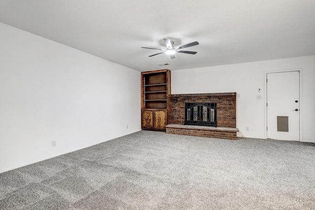 unfurnished living room with carpet flooring, a fireplace, a textured ceiling, and ceiling fan