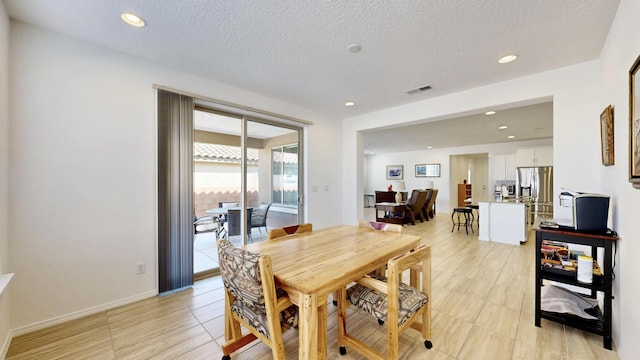 dining room featuring recessed lighting, visible vents, a textured ceiling, and baseboards