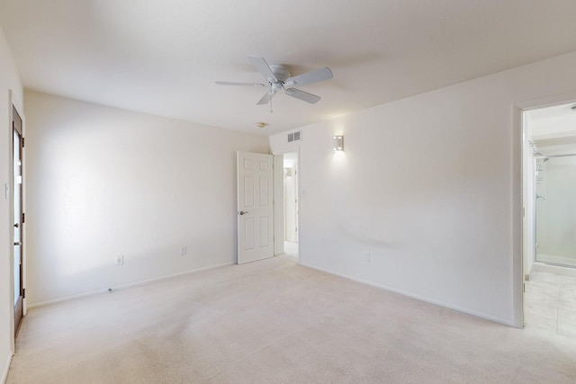 unfurnished room with visible vents, ceiling fan, light carpet, and baseboards