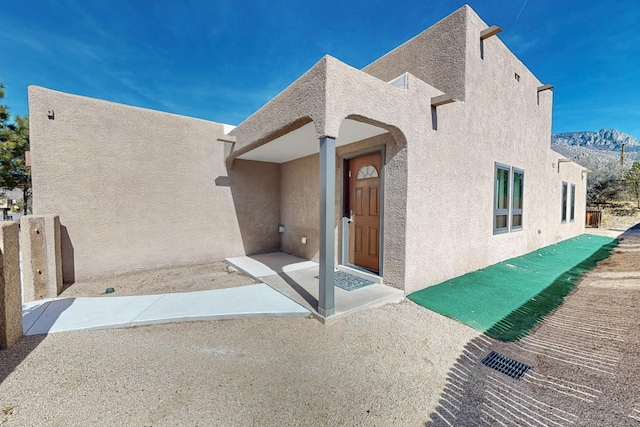 exterior space featuring a mountain view and stucco siding