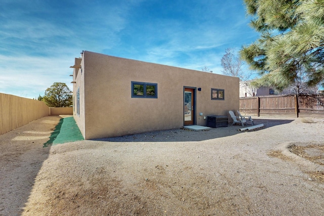 view of front of home with a fenced backyard and stucco siding