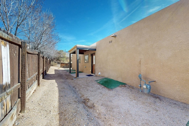 view of home's exterior featuring a patio area, fence, and stucco siding