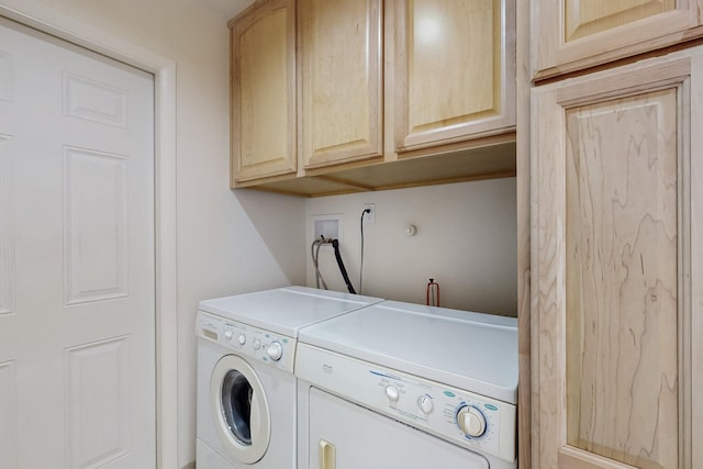 laundry area with independent washer and dryer and cabinet space