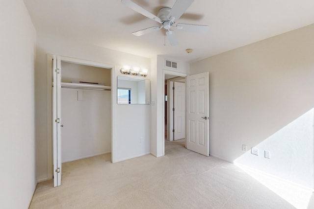 unfurnished bedroom featuring light carpet, ceiling fan, a closet, and visible vents