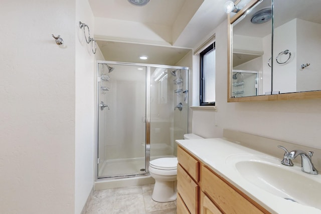 bathroom with vanity, a shower stall, and toilet