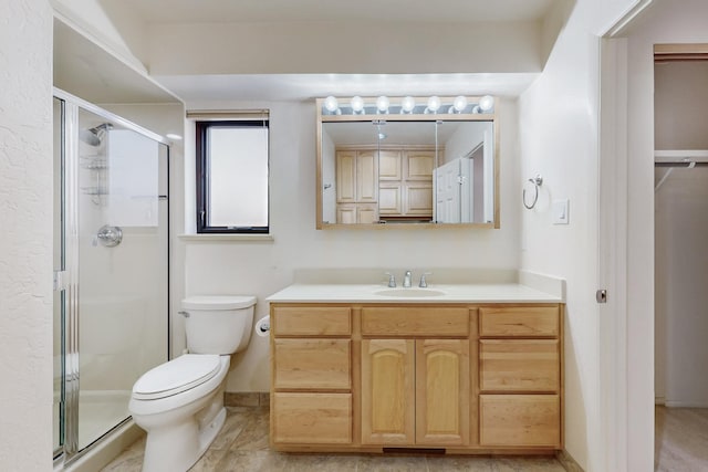 full bath featuring baseboards, a shower stall, toilet, and vanity