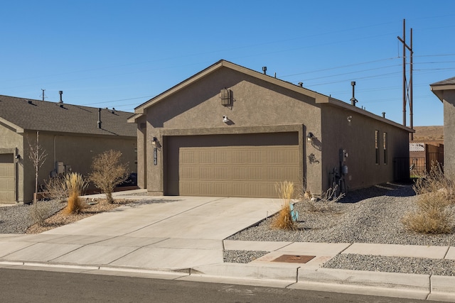 view of front facade featuring concrete driveway, an attached garage, and stucco siding