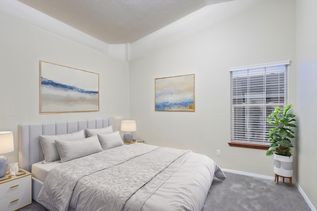 carpeted bedroom featuring vaulted ceiling and baseboards