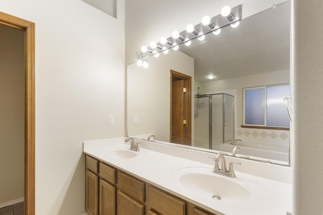 bathroom with double vanity, a shower stall, a sink, and a bath