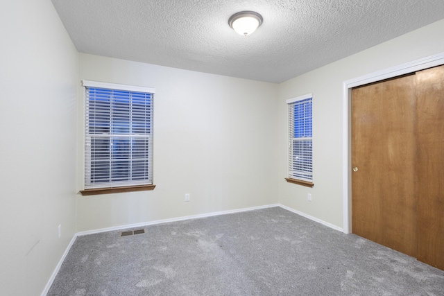 unfurnished bedroom featuring a closet, carpet, visible vents, and baseboards