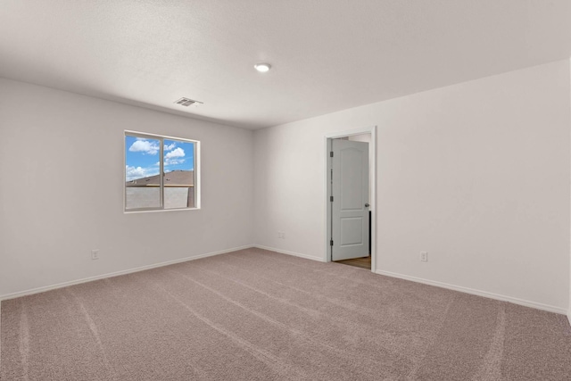 carpeted empty room featuring visible vents and baseboards