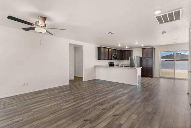 unfurnished living room featuring dark wood-style flooring, visible vents, ceiling fan, and baseboards