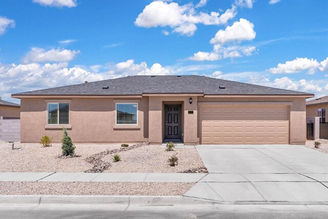 ranch-style house with driveway, an attached garage, roof with shingles, and stucco siding