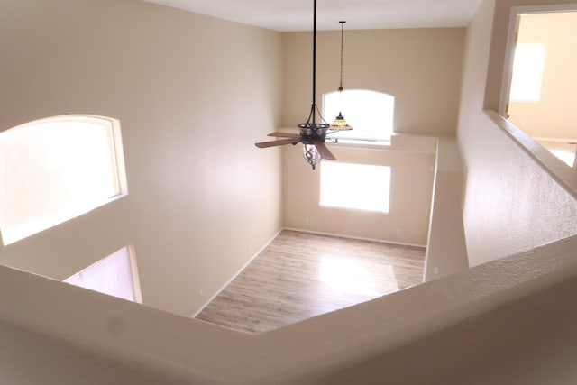 interior space featuring ceiling fan, a high ceiling, and wood finished floors