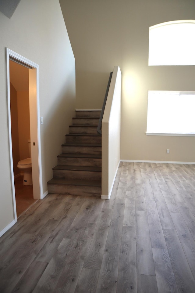 staircase featuring baseboards and wood finished floors