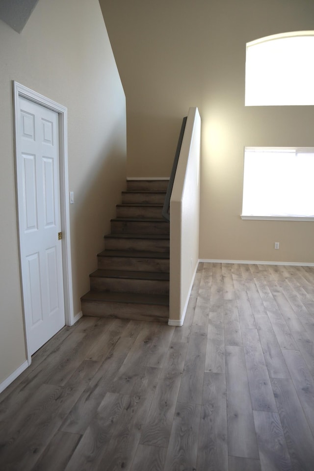 stairs featuring wood finished floors and baseboards