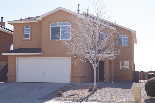 view of front facade featuring driveway, an attached garage, and stucco siding