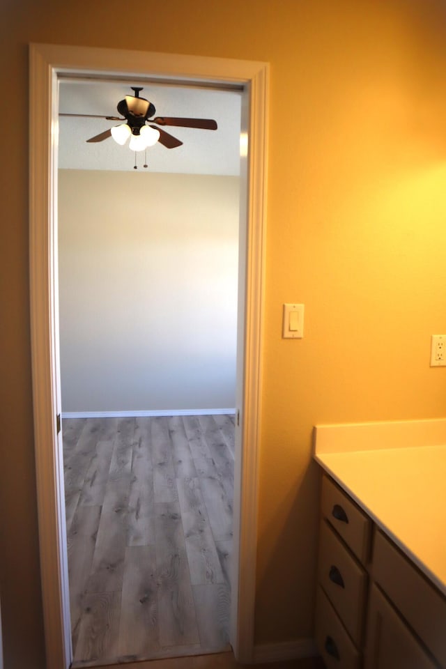 bathroom featuring ceiling fan, wood finished floors, and baseboards