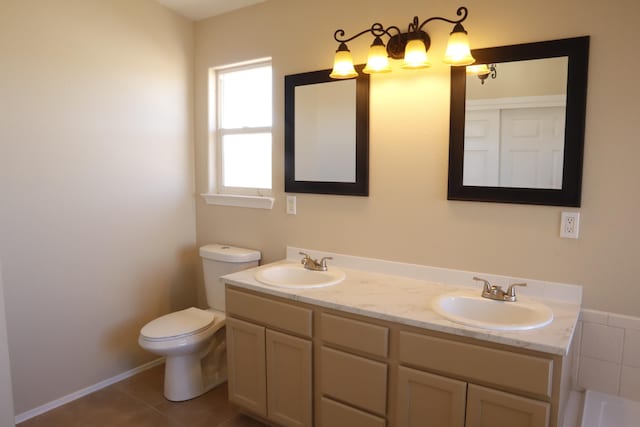 bathroom with double vanity, tile patterned flooring, toilet, and a sink