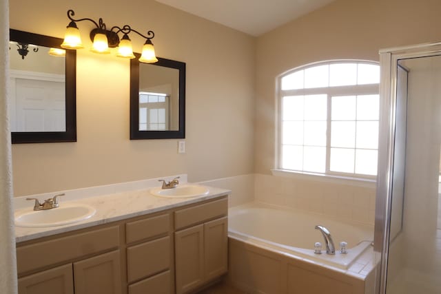 bathroom with a bath, double vanity, a sink, and a shower with shower door