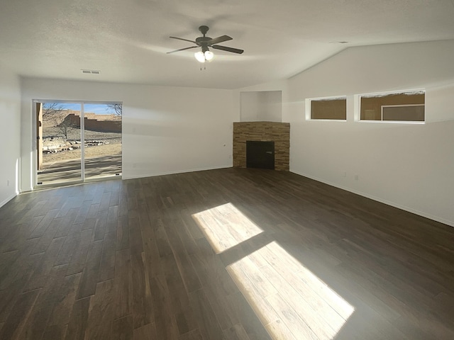 unfurnished living room with dark wood-type flooring, vaulted ceiling, a fireplace, and a ceiling fan