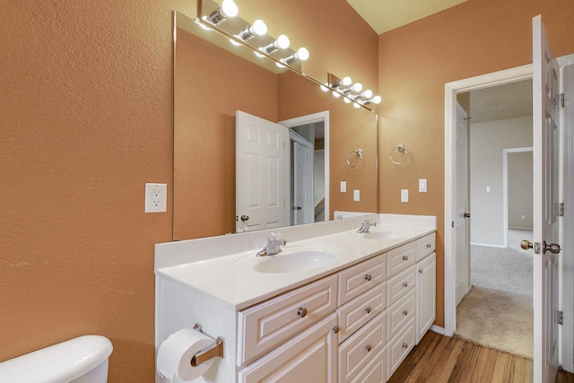 9801 Basha St NW, Albuquerque, NM 87114 - bathroom featuring double vanity, wood finished floors, and a textured wall