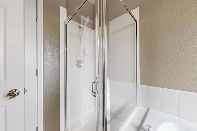 9801 Basha St NW, Albuquerque, NM 87114 - bathroom with a textured wall, a stall shower, and a garden tub