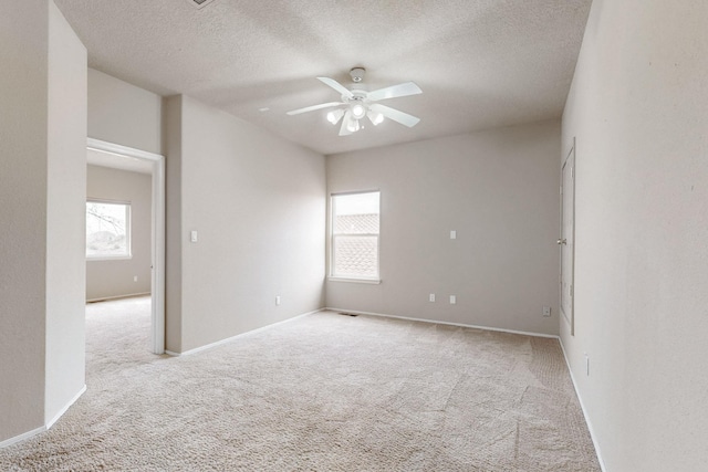 9801 Basha St NW, Albuquerque, NM 87114 - empty room featuring plenty of natural light, a ceiling fan, carpet flooring, and a textured ceiling