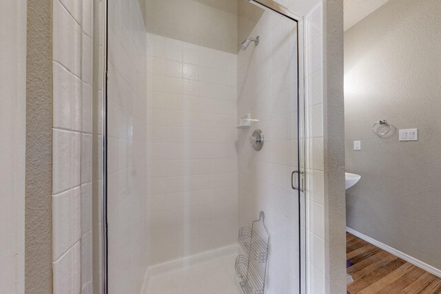 9801 Basha St NW, Albuquerque, NM 87114 - bathroom featuring a shower stall, wood finished floors, and a textured wall