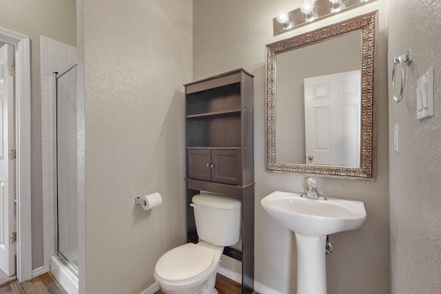9801 Basha St NW, Albuquerque, NM 87114 - full bathroom featuring a shower stall, a textured wall, and wood finished floors