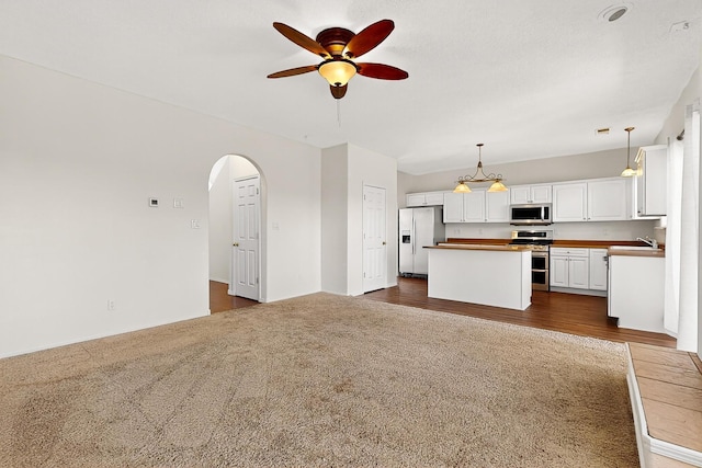 9801 Basha St NW, Albuquerque, NM 87114 - unfurnished living room with a ceiling fan, dark colored carpet, and arched walkways