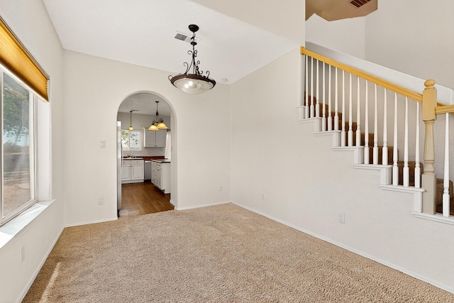 9801 Basha St NW, Albuquerque, NM 87114 - carpeted empty room featuring arched walkways and stairway