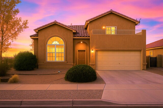 9801 Basha St NW, Albuquerque, NM 87114 - mediterranean / spanish-style house featuring a balcony, concrete driveway, stucco siding, and a garage