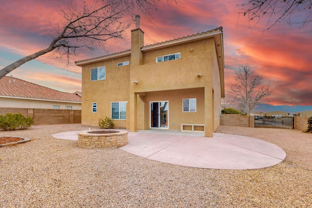 9801 Basha St NW, Albuquerque, NM 87114 - back of property featuring a fire pit, stucco siding, a fenced backyard, a patio area, and a chimney