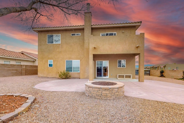 9801 Basha St NW, Albuquerque, NM 87114 - rear view of house with a patio, stucco siding, a fenced backyard, and a fire pit