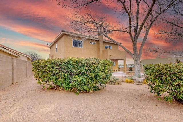 9801 Basha St NW, Albuquerque, NM 87114 - back of property at dusk with stucco siding
