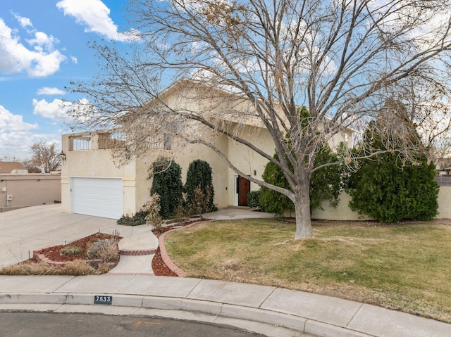 view of front of house with driveway, a front yard, and stucco siding