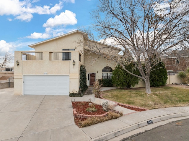 mediterranean / spanish-style home featuring an attached garage, a front lawn, concrete driveway, and stucco siding