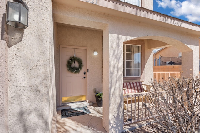 entrance to property featuring stucco siding