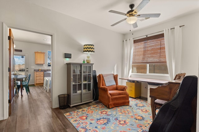 sitting room with ceiling fan and wood finished floors