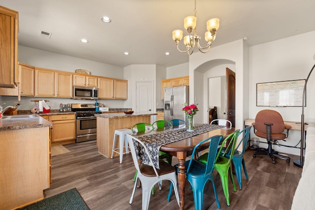 kitchen with visible vents, dark wood finished floors, hanging light fixtures, stainless steel appliances, and a sink