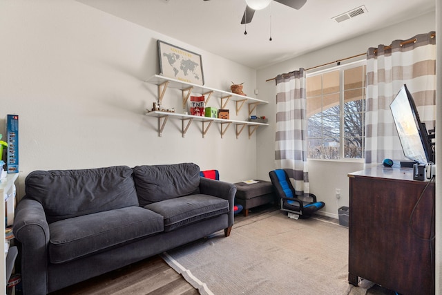 living area with ceiling fan, visible vents, and baseboards