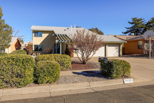 view of front facade featuring driveway, an attached garage, and stucco siding